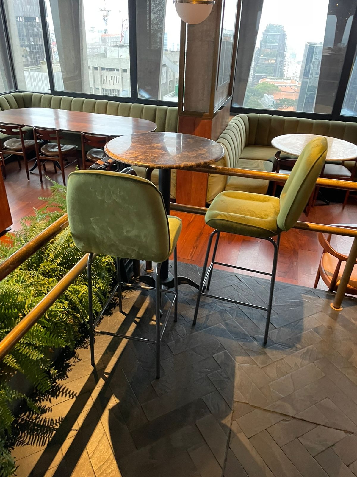 Banquetas altas com estrutura tubular metálica em ambiente de restaurante